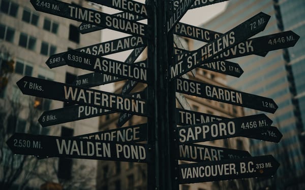 multiple road signs pointing to multiple locations